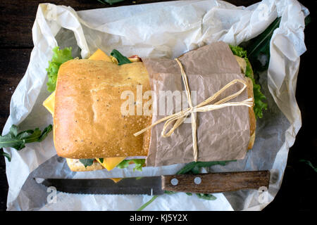 Focaccia sandwich gefüllt mit Schinken und Käse auf hölzernen Hintergrund von oben, selektiver Fokus Stockfoto