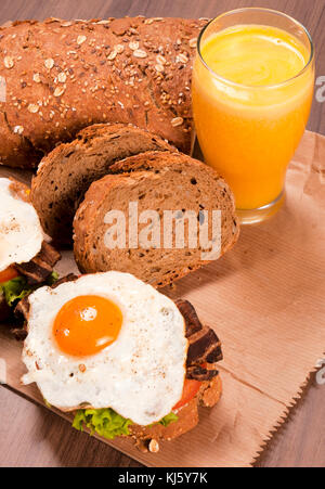 Frisch gebratene Eier und Orangensaft auf dem hölzernen Tisch Stockfoto