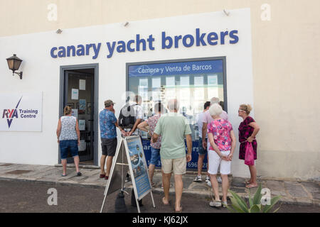LANZAROTE, Spanien, 4. November 2017: Eine Gruppe von Touristen nehmen Interessen in einer Reihe von yacts, die zum Verkauf auf den Kanarischen Yacht Brokers in Playa Blanca. Stockfoto