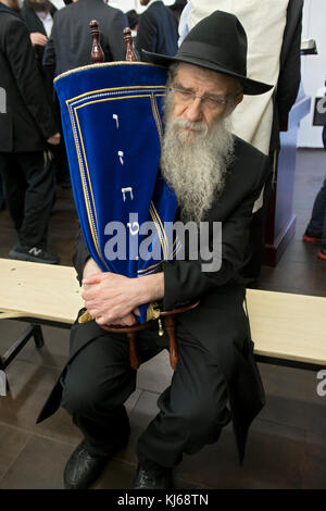 Eine orthodoxe chassidischen Rabbi hält eine Torarolle, nachdem sie gelesen wurde und bevor es zum Heiligen Arche in Cambria Heights, Queens, New York City, Stockfoto