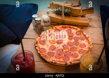 Weihnachten essen Pizza mit Limonade auf den Tisch mit Bündel von Brennholz Stockfoto