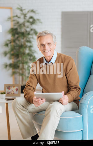 Freundlich aussehenden alten Herrn auf Tablet-PC Stockfoto