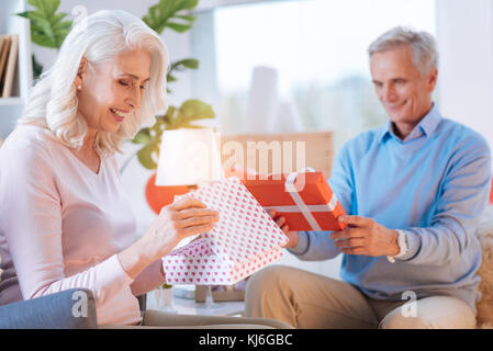 Aufgeregt, Mann und Frau, ihre Geschenke öffnen Stockfoto