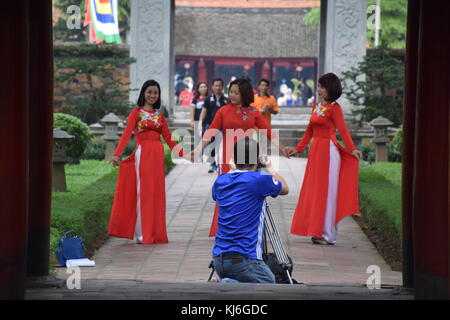 Drei schöne vietnamesische Frauen in rot gekleidet posiert für ein Foto schießen im inneren Tempel der Literatur in Hanoi, Vietnam Stockfoto