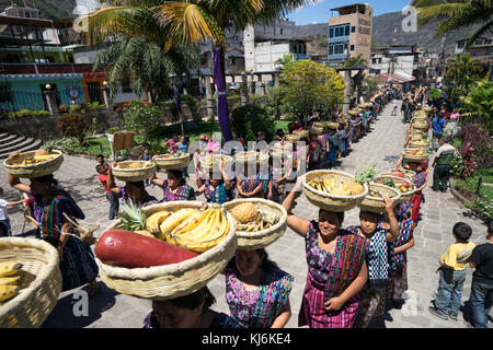 Maya tzutujil Frauen mit Obst Körbe auf dem Kopf der lokalen Kirche auf Ostern Karwoche Feier eingeben Stockfoto