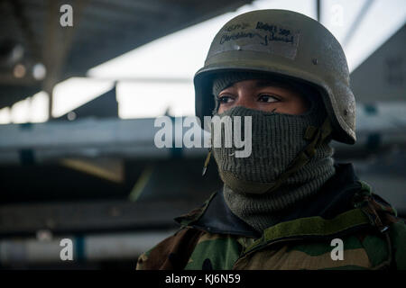 Us Air Force Senior Airman Jamal Christian, 20 Aircraft Maintenance Squadron Tactical Aircraft Maintainer, wartet auf den Pilotenschein Anreise neben einem CM F-16 Fighting Falcon bei Shaw Air Force Base, South Carolina, Nov. 16, 2017. Wartung Flieger gestartet und Feste F-16 s mit verschiedenen Hindernissen einschließlich simulierten Kommunikationsprobleme und chemischen, biologischen, radiologischen und nuklearen Bedrohungen sowie das kalte Wetter. (U.S. Air Force Foto von Airman 1st Class Destinee Sweeney) Stockfoto