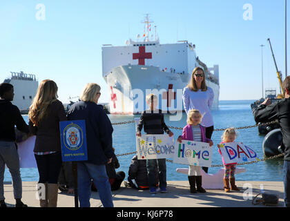 NORFOLK, VA. (20. November 2017) – Familie und Freunde von Besatzungsmitgliedern an Bord des Lazarettschiffes des Militärkommandos USNS Comfort (T-AH 20) warten, während das Schiff in die Naval Station Norfolk am 20. November einfährt. Comfort kehrte nach Virginia zurück, nachdem er seine medizinische Mission zur Unterstützung der Federal Emergency Management Agency und der Hurrikanhilfe des US-Gesundheitsministeriums in Puerto Rico abgeschlossen hatte. Während in Puerto Rico Comfort behandelt 1,899 Patienten, durchgeführt 191 Operationen, zur Verfügung gestellt 76,000 Liter Sauerstoff und 10 Tonnen Nahrung und Wasser. (USA Navy Foto von Bill MES Stockfoto