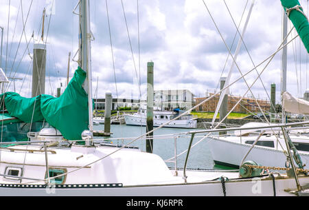 Durch Segelboot Yacht die Masten und die Takelage zu neuen Haus Bau Baustelle in Marsden Cove Marina, Whangarei, Northland, Neuseeland, NZ Stockfoto