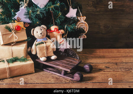 Weihnachten Geschenke mit Kästen auf Holz- Hintergrund. Vintage Style. closeup, selektive konzentrieren. Spielzeug, Bär, Schlitten. Weihnachten Konzept. Stockfoto