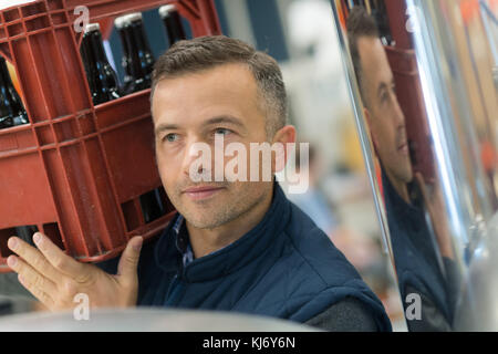 Mann, der Kiste Bier Stockfoto