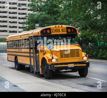 Einen gelben Schulbus in Chicago Downtown geparkt wird, warten auf die Teilnehmer. Vorderansicht, USA.. Stockfoto