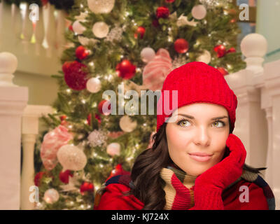 Herzlich Frau vor geschmückten Weihnachtsbaum gekleidet. Stockfoto