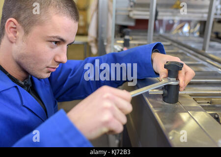 Junge Arbeiter, der die Maschine Stockfoto