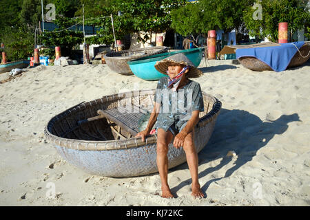 Vietnamesische Fischerin mit einem traditionellen runden Korbkorbboot Stockfoto