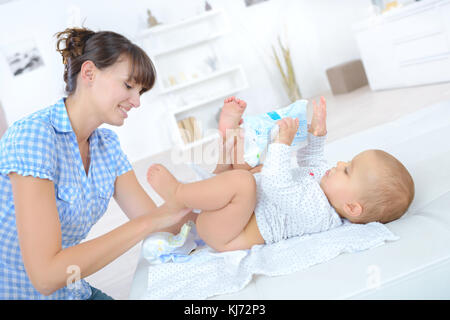 Mutter Windelwechsel ein neun Monate altes Baby Stockfoto