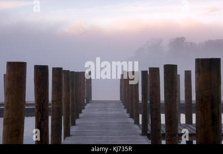 Nebliger Herbstmorgen auf einer Anlegestelle in Derwentwater im Lake District, Keswick Cumbria England Stockfoto