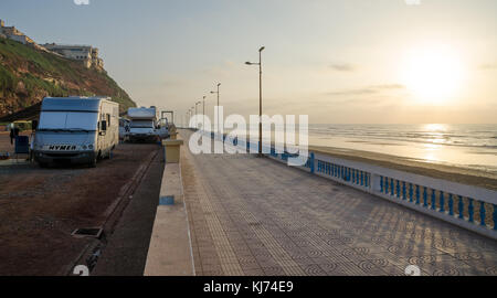 Sidi Ifni, Marokko - 20. September 2013: Wohnmobile Camping neben dem Stein Strand Promenade im malerischen Sonnenuntergang Stockfoto