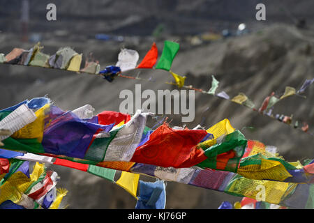 Helle buddhistische Gebetsfahnen im Wind vor dem Hintergrund der Berge. Stockfoto