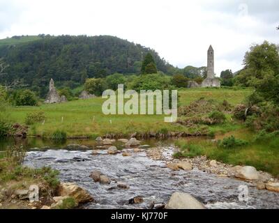 Idyllische irische Landschaft mit runder Turm eines alten Klosters im Hintergrund Stockfoto