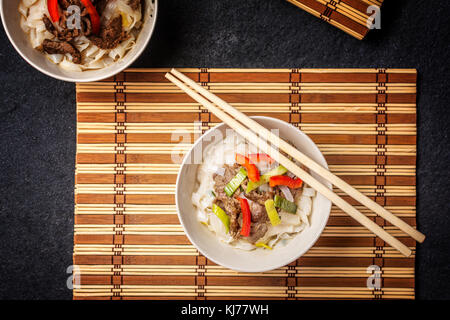 Traditionelle Pho Bo vietnamesische Suppe mit Rindfleisch in weiße Platte und Essstäbchen Stockfoto