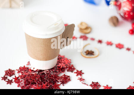 Papier Tasse Kaffee von Weihnachtsschmuck zu Weihnachten Dekor auf weißem Hintergrund Hintergrund umgeben Stockfoto