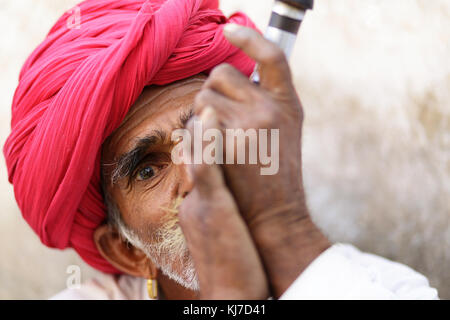 Mitglied der ethnischen Minderheit - rabari Mann rauchen Tonpfeife. Foto bei Landschaft in der Nähe von Jodhpur, Rajasthan, Indien. Stockfoto