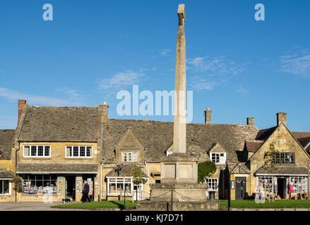 War Memorial steinernen Kreuz in Cotswolds Dorfzentrum von Cotswold stone Geschäfte übersehen. High Street, Broadway, Worcestershire, England, Großbritannien, Großbritannien Stockfoto