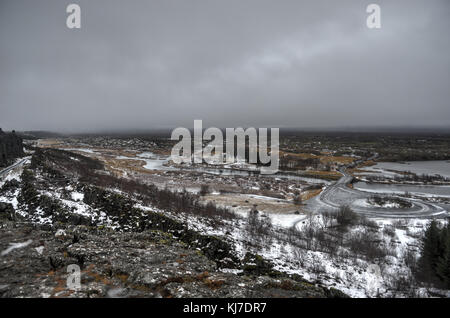 Typische ländliche isländischen Kirche, Friedhof und Häuser im Thingvellir Nationalpark auf eine winterliche bewölkten Tag. Stockfoto