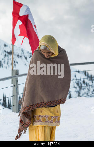 Frau im Schnee mit der kanadischen Flagge schwenkten hinter ihr, Whistler, British Columbia, Kanada Stockfoto