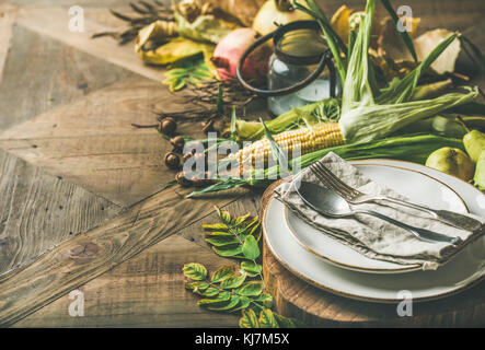 Herbst Tabelle Einstellung für Thanksgiving Day Feier. Teller, Besteck, Kerzenhalter, Herbst Gemüse der Saison, Obst und gefallenen gelbe Blätter für dec Stockfoto