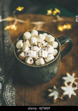 Weihnachten oder Neujahr Winter heiße Schokolade mit Marshmallows und Lebkuchen Cookies über Holzbrett serviert mit Urlaub Lichterkette, Decke und Stockfoto