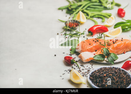 Rohen ungekochten Lachs Fisch Filet Steak mit Gemüse, Gemüse, Reis und Gewürze über grauem Marmor Hintergrund, kopieren. Sauber Essen, basische Ernährung, Stockfoto