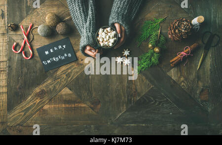 Weihnachten, Neujahr Urlaub Vorbereitung Hintergrund. Grußkarte, glitzerndes Spielzeug, Hände der Frau mit Becher heißer Schokolade, Zimt, Stockfoto