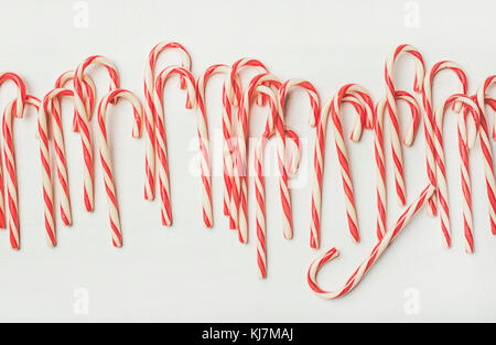 Weihnachten rot gestreifte Zuckerstange Muster, Textur und Hintergrund auf weiß, Ansicht von oben, Flachbild-Lay, horizontale Zusammensetzung Stockfoto