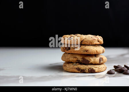 Gestapelte Chocolate Chip Cookies auf weißem Marmor tisch Stockfoto