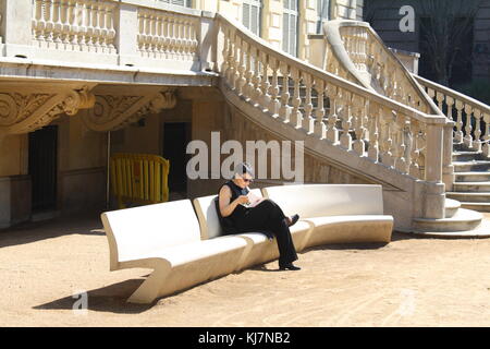 Eine gemütliche, komfortable Designbank vor einem klassischen Denkmalgebäude. Stockfoto
