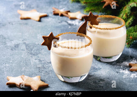 Eierkuchen Weihnachten Milch Cocktail mit Zimt, serviert in zwei Gläsern mit Shortbread Stern Form Zucker Kekse in verschiedenen Größen, Dekor Spielzeug, Tannenzweig ov Stockfoto