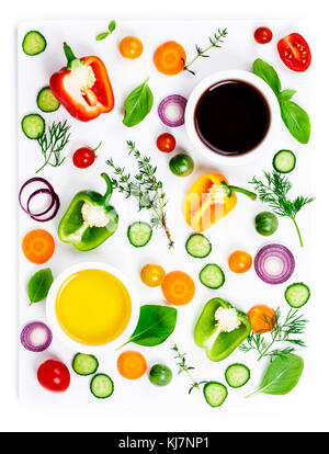 Zusammensetzung von frischem Gemüse (Paprika, Zwiebeln, Gurken, Karotten, Tomaten), Kräuter, Olivenöl und Essig auf weißem Hintergrund, oben vi. Stockfoto