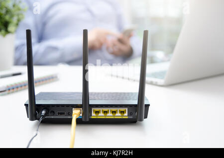 Wireless Router und mit einem smart phone in Haus oder Büro Mann. Router Wireless Broadband home smart phone wlan Technologie Konzept Stockfoto