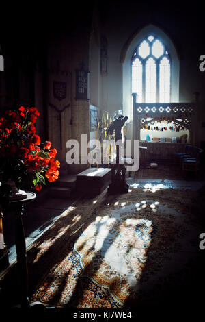 Mohnblumen, die vom Sonnenlicht, das durch das Fenster strömte, am Gedenktag in der Pfarrkirche St. Marys, Netherbury, Dorset, Großbritannien - John Gollop, gefangen wurden Stockfoto