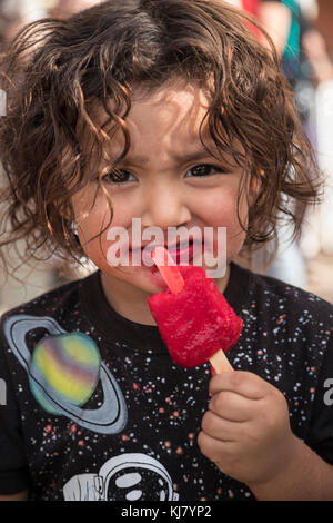 Nogales Sonora, Mexiko - ein Kind isst eine rote Popsicle. Stockfoto