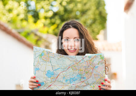 Eine schöne weibliche Touristen auf der Suche nach einem Ort auf der Karte Stockfoto