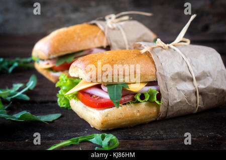 Beliebte Panini belegte Brötchen mit Schinken und Käse auf der hölzernen Hintergrund, selektiver Fokus Stockfoto