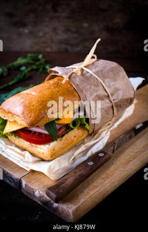 Gefüllte Sandwich mit Schinken und Käse auf dem Holzbrett, selektiver Fokus Stockfoto