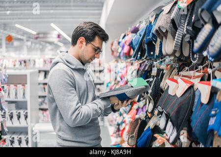 Kunden man Auswahl home Hausschuhe im Supermarkt Mall Stockfoto