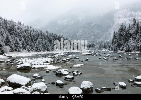 Schnee fällt auf dem Chilkoot River im Südosten Alaskas. Stockfoto