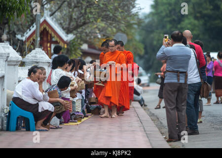 Luang Prabang, Laos - 19. November 2017: Toristen fotografieren buddhistische Mönche jeden Morgen traditionelle Almosengaben in Luang Prabang, Laos. Stockfoto