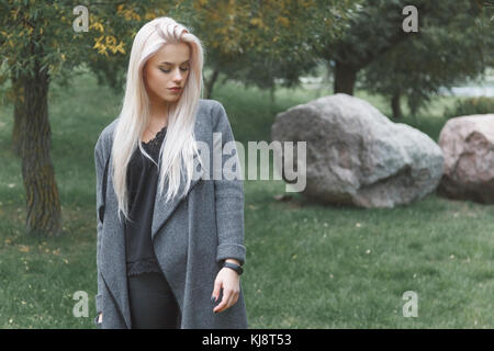 Porträt der jungen blondhair elegant gekleidete Frau in einem Mantel mit Schickes Armband steht im Freien. Stockfoto