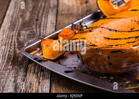 Gebratener Kürbis mit Thymian und Balsamico auf der Oberseite über rustikalen Holztisch Glasur, Herbst gemütliche Dish Stockfoto