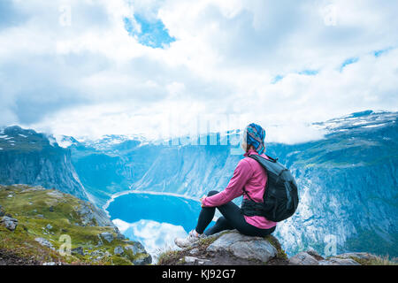 Junge Frau mit Rucksack auf Fjord Norwegen Stockfoto